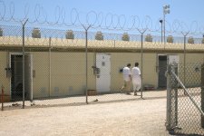 Detainees walk around the exercise yard in Camp 4, the medium security facility within Camp Delta at Naval Station Guantanamo Bay, Cuba