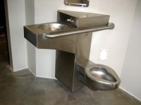 Camp 5 cell featuring an overhanging sink to accommodate detainees with disabilities who can use a wheelchair and a grab bar on the commode