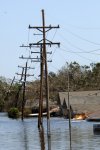 Natural gas leaking from below the flooded streets of New Orleans, La., and burning out of control near flooded homes