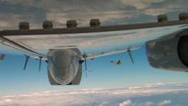 View of a jet flying near another one, which is partly visible in the foreground.
