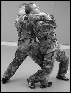Figure 8-2. Defense against the standing rear naked choke leaning back.