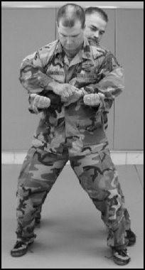 Figure 8-7. Defense against the bear hug from the rear, over the arms.