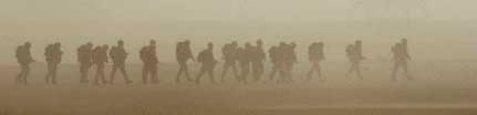 Soldiers emerge from a dust cloud