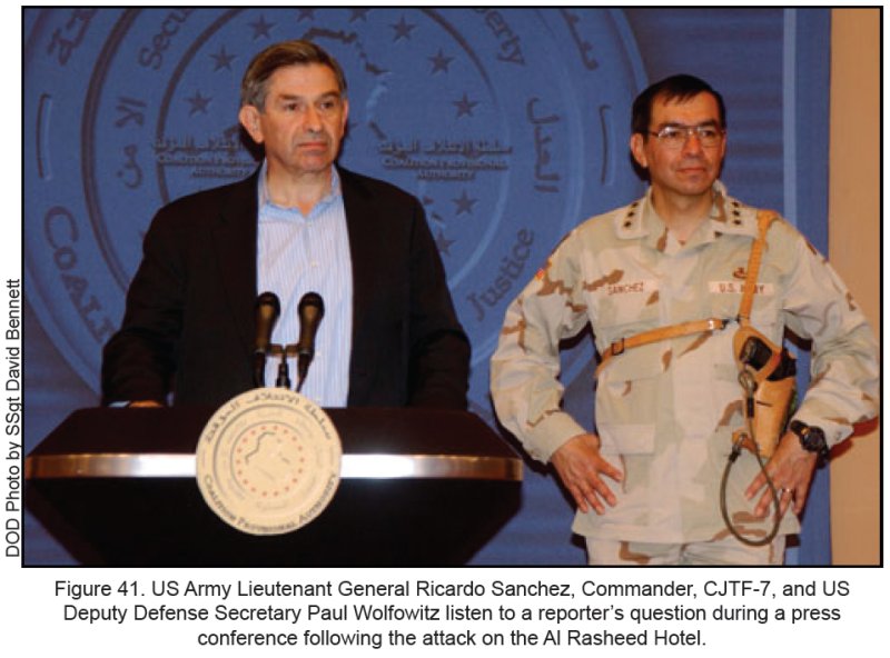Figure 41. US Army Lieutenant General Ricardo Sanchez, Commander, CJTF-7, and US Deputy Defense Secretary Paul Wolfowitz listen to a reporter's question during a press conference following the attack on the AL Rasheed Hotel. Figure 41. US Army Lieutenant General Ricardo Sanchez, Commander, CJTF-7, and US Deputy Defense Secretary Paul Wolfowitz listen to a reporter's question during a press conference following the attack on the AL Rasheed Hotel.