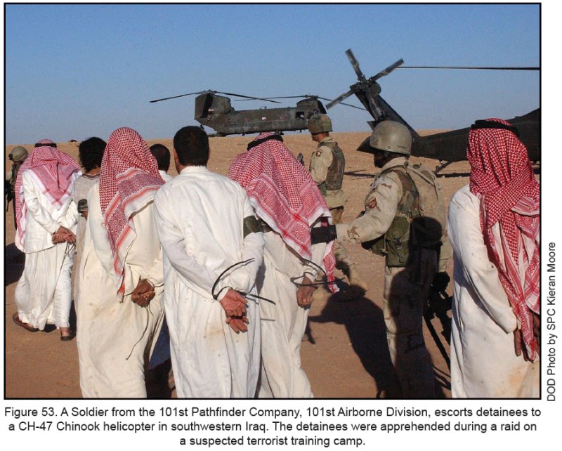 Figure 53. A Soldier from the 101st Pathfinder Company, 101st Airborne Division, escorts detainees to a CH-47 Chinook helicopter in southwestern Iraq. the detainees were apprehended during a raid on a suspected terrorist training camp.