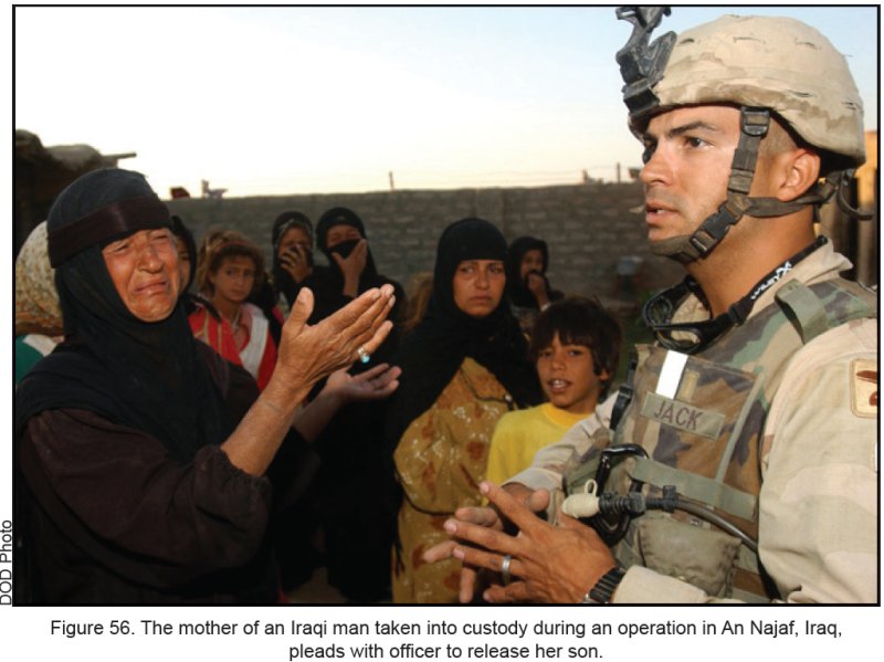 Figure 56. The mother of an Iraqi man taken into custody during an operation in An Najaf, Iraq, pleads with officer to release her son.