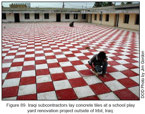 Figure 89. Iraqi subcontractors lay concrete tiles at a school play yard renovation project outside of Irbil, Iraq.