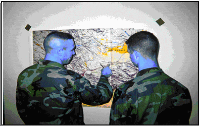 photo of leaders studying a map of the area of operations while planning a COA