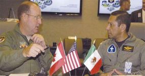 Photo of U.S. First Air Force commander Major General Hank Morrow (left) discusses North American homeland operations with Major General Carlos Antonio Rodriquez Munguia