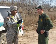Photo showing  Soldier and a JTF North border-road mission discussing a U.S. Border Patrol agent providing security for the military engineers