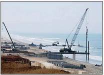 Photo of a 175-ton crane moves pile sections into place