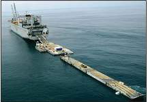 Photo of and improved Navy lighterage system (INLS) barge ferry moves into position astern of USNS Pililaau in preparation for equipment offload