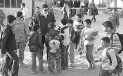 Howard Van Vranken, a representative from the Babil Provincial Reconstruction Team, talks to Iraqi children outside the General Cultural Center in Iskandariyah, Iraq, 3 December 2008