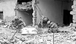 Law-enforcement professionals (LEPs) embedded with 4th Brigade, 2nd Infantry Division, collect evidence at the scene of a house-borne improvised explosive device in the Diyala River Valley, Iraq. Contracted civilians, LEPs provide soldiers expertise and training in collecting, refining and extrapolating intelligence.
