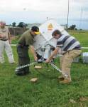 Photo showing Department of the Army civilian PAOs set up a satellite communications device at the airfield in Entebbe, Uganda