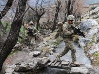 Soldier, wearing OEF Camouflage Pattern on his uniform, crosses a stream during a unit visit to Angla Kala village in Afghanistan's Kunar province, Feb. 6, 2010. Soldiers going to Afghanistan will now be issued the new OCP Fire Resistant Army Combat Uniform.