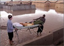Two Army soldiers remove a bunk from their flooded tent at Kirkuk AB, Iraq, Jan. 13, 2004. The base was hit by nearly 2 inches of rain overnight, leaving many areas of the base, including tents for airmen and soldiers, deluged with water