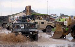 Airmen from the 506th Expeditionary CES work to control flooding over a road at Kirkuk AB, Iraq, Jan. 13, 2004