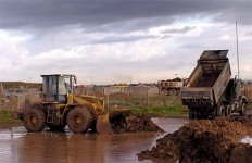 Airmen from the 506th Expeditionary CES work to control flooding over a road at Kirkuk AB, Iraq, Jan. 13, 2004