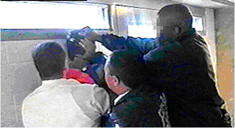 Image 4:  Officers firmly press detainee's head against the wall.