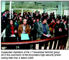 Suspected members of the 17 November terrorist group sit in the courtroom of the Korydallos high-security prison during their trial, 6 March 2003. [AFP photo]