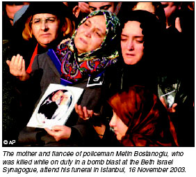 The mother and fiancee of policeman Metin Bostanoglu, who was killed while on duty in a bomb blast at the Beth Israel Synagogue, attend his funeral, 16 November 2003. 