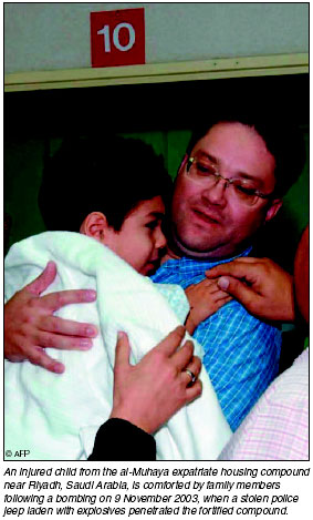 An injured child from the al-Muhaya expatriate housing compound near Riyada, is comforted by family members following a bombing on 9 November 2003, [AFP photo]