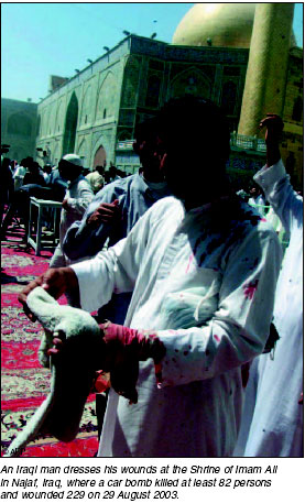 An Iraqi man dresses his wounds at the Shrine of Imam Ali in Najaf, Iraq, where a car bomb killed at least 82 persons and wounded 229, 29 August 2003.