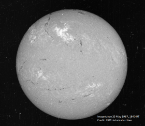 A view of the Sun on May 23, 1967, in a narrow visible wavelength of light called Hydrogen-alpha. The bright region in the top center region of brightness shows the area where the large flare occurred. Credit: National Solar Observatory historical archive.